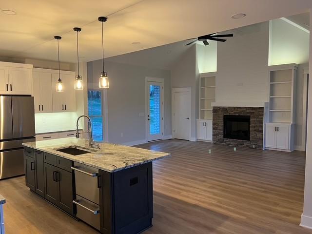 8246 Aedc Rd, Estill Springs, TN 37330 - kitchen with appliances with stainless steel finishes, ceiling fan, wood finished floors, white cabinets, and light stone countertops