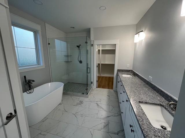 8246 Aedc Rd, Estill Springs, TN 37330 - bathroom with a stall shower, marble look tiles, double vanity, a freestanding bath, and a spacious closet