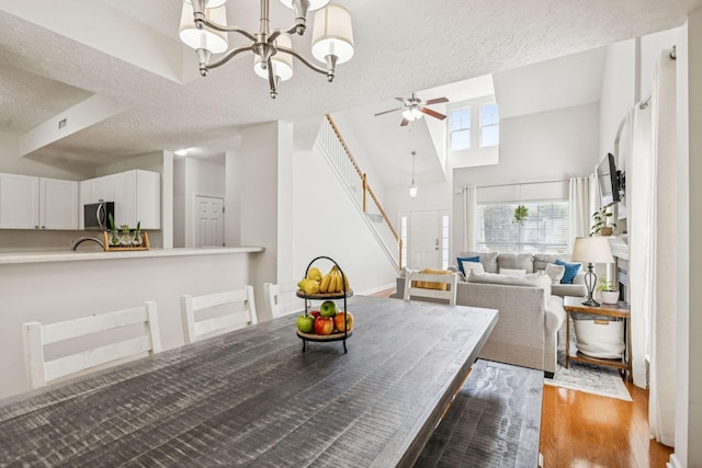 1443 Bern Dr, Spring Hill, TN 37174 - dining area featuring a textured ceiling, wood finished floors, a chandelier, stairway, and ceiling fan