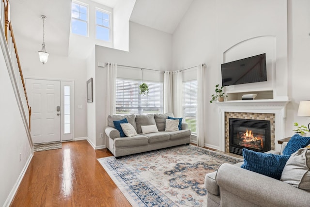 1443 Bern Dr, Spring Hill, TN 37174 - living area featuring healthy amount of natural light, wood finished floors, high vaulted ceiling, and a glass covered fireplace