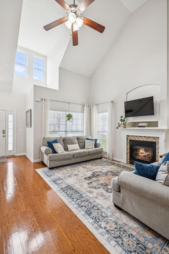 1443 Bern Dr, Spring Hill, TN 37174 - living area with high vaulted ceiling, wood finished floors, a glass covered fireplace, and a ceiling fan