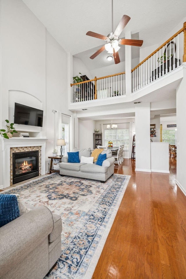 1443 Bern Dr, Spring Hill, TN 37174 - living area featuring ceiling fan, plenty of natural light, a glass covered fireplace, wood-type flooring, and high vaulted ceiling