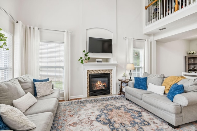 1443 Bern Dr, Spring Hill, TN 37174 - living room featuring a glass covered fireplace, a towering ceiling, and wood finished floors