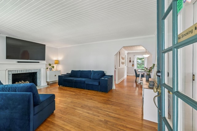 1338 Ardee Ave, Nashville, TN 37216 - living area with crown molding, arched walkways, light wood-style flooring, and a brick fireplace