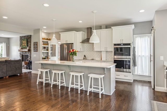 5077 Joe Peay Rd, Spring Hill, TN 37174 - kitchen with stainless steel appliances, wall chimney exhaust hood, light countertops, white cabinets, and recessed lighting
