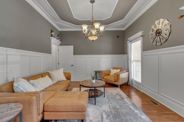 1051 Fitzroy Cir, Spring Hill, TN 37174 - living area with a decorative wall, a tray ceiling, a chandelier, wood finished floors, and a wainscoted wall