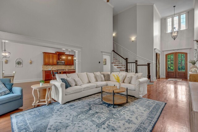 1051 Fitzroy Cir, Spring Hill, TN 37174 - living room featuring a towering ceiling, a chandelier, healthy amount of natural light, stairs, and crown molding