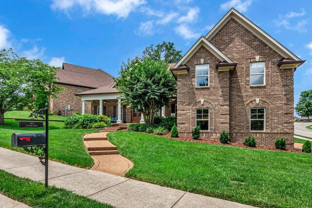1051 Fitzroy Cir, Spring Hill, TN 37174 - view of front of home featuring brick siding, a front lawn, and a porch