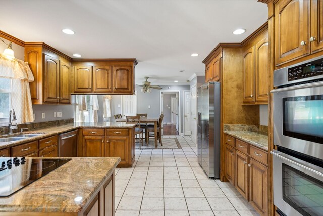 519 Hemingway Dr, Columbia, TN 38401 - kitchen with appliances with stainless steel finishes, brown cabinetry, a ceiling fan, light stone counters, and ornamental molding