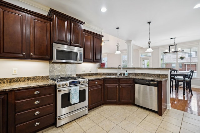 3002 Stow Xing, Murfreesboro, TN 37128 - kitchen featuring appliances with stainless steel finishes, a peninsula, dark brown cabinetry, light tile patterned flooring, and recessed lighting