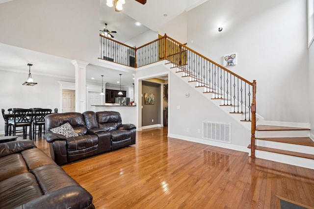 3002 Stow Xing, Murfreesboro, TN 37128 - living room with ceiling fan, light wood-type flooring, stairs, crown molding, and a high ceiling