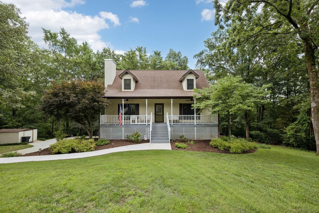 4457 Tanglewood Rd, Pegram, TN 37143 - cape cod-style house featuring a porch, a front yard, a chimney, and a ceiling fan