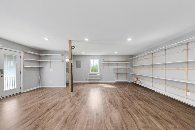 369 Springwater Dr, Summertown, TN 38483 - unfurnished living room featuring a wall mounted AC, electric panel, wood finished floors, and recessed lighting