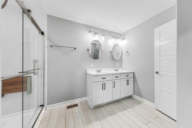 369 Springwater Dr, Summertown, TN 38483 - full bath featuring double vanity, a tile shower, and wood finished floors