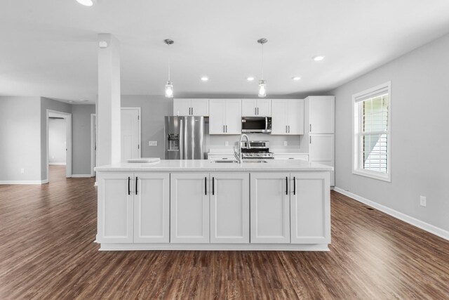 369 Springwater Dr, Summertown, TN 38483 - kitchen featuring appliances with stainless steel finishes, white cabinets, light countertops, a center island with sink, and dark wood-style flooring
