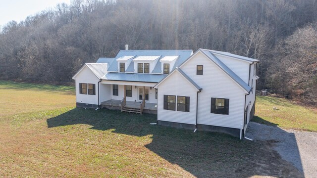 3310 Rocky Branch Rd, Watertown, TN 37184 - modern farmhouse style home with covered porch, a forest view, and a front lawn