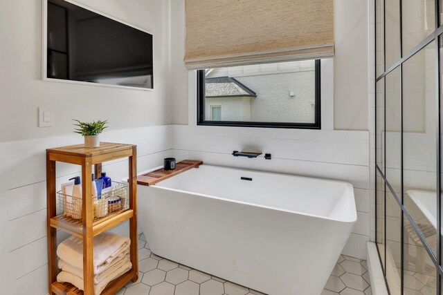7025 Lanceleaf Dr, College Grove, TN 37046 - bathroom featuring a freestanding bath, tile patterned floors, and tile walls