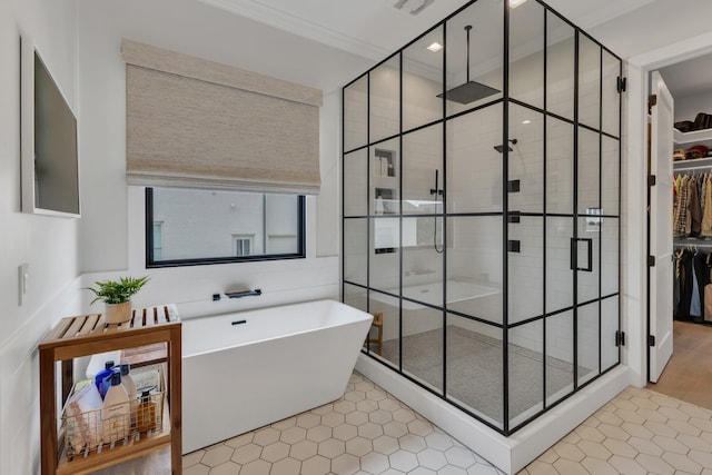 7025 Lanceleaf Dr, College Grove, TN 37046 - bathroom featuring a stall shower, a soaking tub, a spacious closet, tile patterned floors, and crown molding