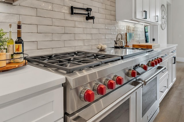7025 Lanceleaf Dr, College Grove, TN 37046 - kitchen featuring double oven range, tasteful backsplash, white cabinets, and light countertops