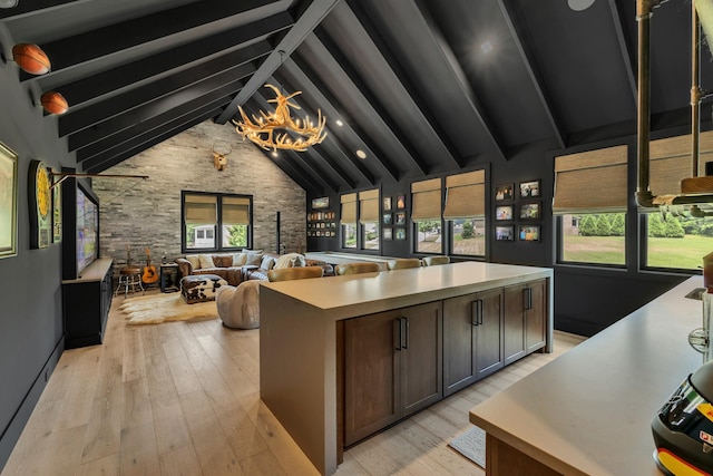 7025 Lanceleaf Dr, College Grove, TN 37046 - kitchen featuring beam ceiling, light countertops, light wood-style flooring, open floor plan, and high vaulted ceiling