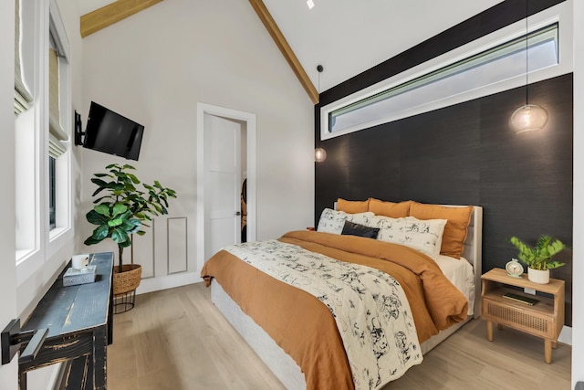 7025 Lanceleaf Dr, College Grove, TN 37046 - bedroom with wood finished floors, beamed ceiling, multiple windows, an accent wall, and high vaulted ceiling