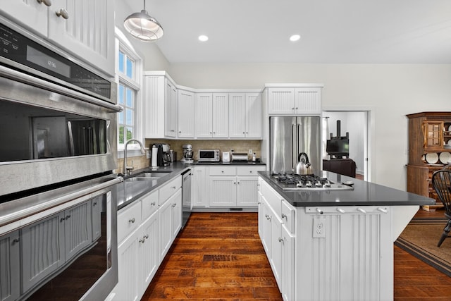 123 Jones Rd, Taft, TN 38488 - kitchen featuring appliances with stainless steel finishes, backsplash, white cabinets, dark countertops, and a kitchen island