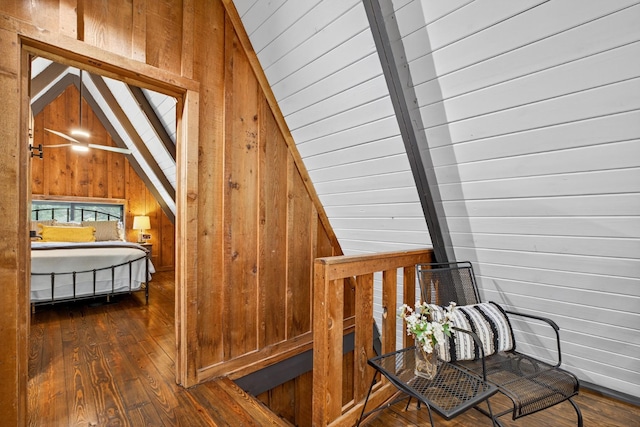 123 Jones Rd, Taft, TN 38488 - stairway with vaulted ceiling, wood walls, and hardwood / wood-style flooring