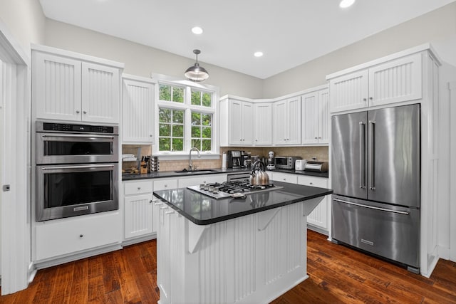 123 Jones Rd, Taft, TN 38488 - kitchen featuring appliances with stainless steel finishes, dark countertops, tasteful backsplash, recessed lighting, and dark wood-type flooring