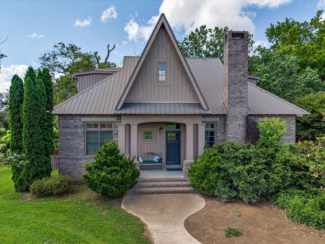 123 Jones Rd, Taft, TN 38488 - view of front facade featuring covered porch, a chimney, board and batten siding, a metal roof, and a standing seam roof