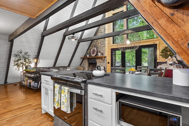 123 Jones Rd, Taft, TN 38488 - kitchen with electric range, white cabinets, dark countertops, light wood-type flooring, and a stone fireplace