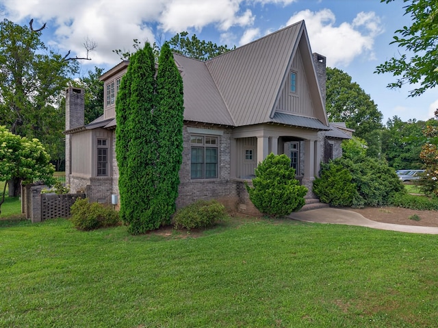 123 Jones Rd, Taft, TN 38488 - view of front of home featuring a chimney, a front yard, brick siding, and a metal roof