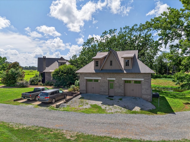 123 Jones Rd, Taft, TN 38488 - view of front of house with a detached garage, a metal roof, a front lawn, and brick siding