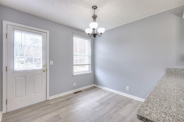5766 Amalie Dr, Nashville, TN 37211 - unfurnished dining area with a chandelier, light wood-style flooring, and a textured ceiling