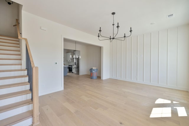 4068 Penfield Dr Unit C, Franklin, TN 37069 - unfurnished living room featuring a chandelier, light wood finished floors, and stairway