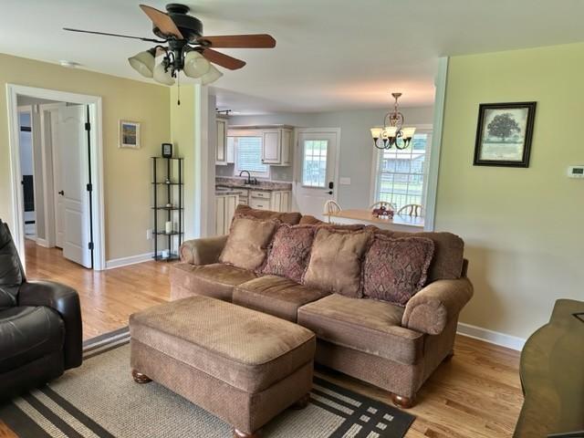 2244 Baptist Branch Rd, Mount Pleasant, TN 38474 - living area with light wood-type flooring, a chandelier, and a ceiling fan