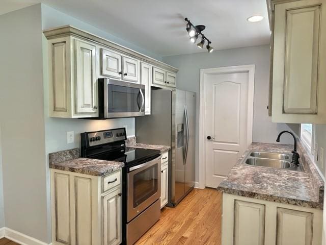 2244 Baptist Branch Rd, Mount Pleasant, TN 38474 - kitchen featuring stainless steel appliances, light wood-style flooring, and cream cabinetry