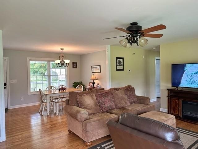 2244 Baptist Branch Rd, Mount Pleasant, TN 38474 - living area featuring a chandelier, wood finished floors, a ceiling fan, and a glass covered fireplace