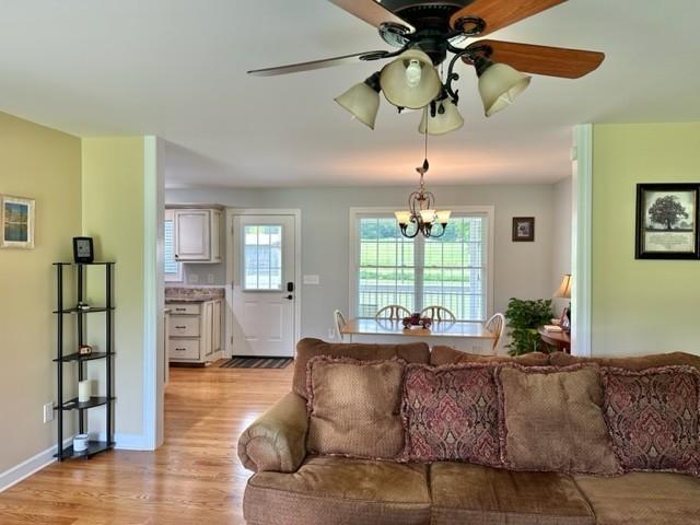 2244 Baptist Branch Rd, Mount Pleasant, TN 38474 - living room with light wood-style floors, a chandelier, and a ceiling fan