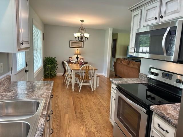 2244 Baptist Branch Rd, Mount Pleasant, TN 38474 - kitchen with appliances with stainless steel finishes, a chandelier, light wood-style floors, and hanging light fixtures