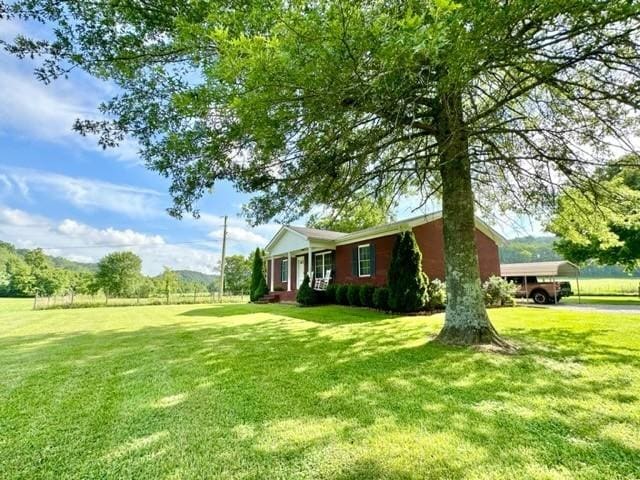 2244 Baptist Branch Rd, Mount Pleasant, TN 38474 - view of home's exterior featuring a yard, a porch, and a carport