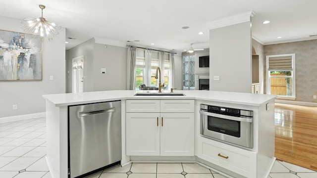 2976 Kingston Cir S, Mount Juliet, TN 37122 - kitchen featuring stainless steel dishwasher, open floor plan, light countertops, plenty of natural light, and ornamental molding