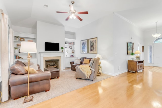 5019 John Hagar Rd, Hermitage, TN 37076 - living area featuring wood finished floors, a ceiling fan, built in shelves, lofted ceiling, and a fireplace with flush hearth