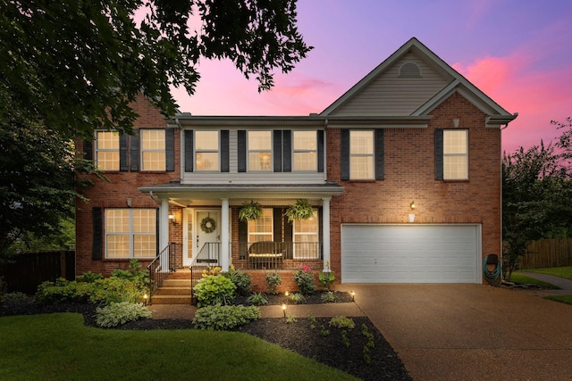 2684 Wind Dance Ct, Spring Hill, TN 37174 - view of front facade featuring a garage, concrete driveway, covered porch, and brick siding