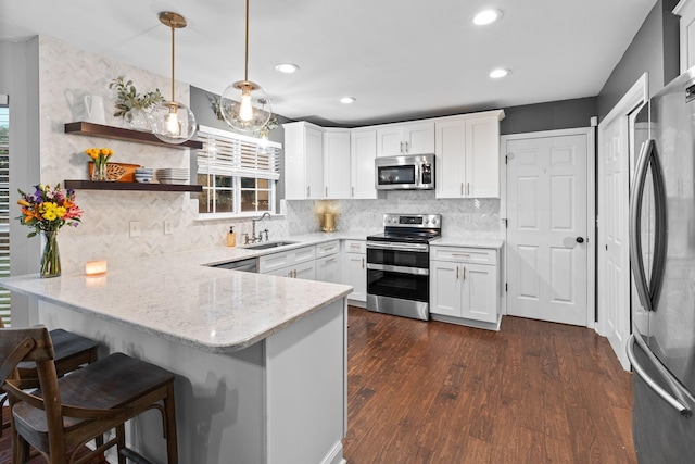 2684 Wind Dance Ct, Spring Hill, TN 37174 - kitchen featuring stainless steel appliances, a peninsula, white cabinets, backsplash, and recessed lighting