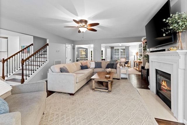 2684 Wind Dance Ct, Spring Hill, TN 37174 - living area with a fireplace with flush hearth, a ceiling fan, and stairs