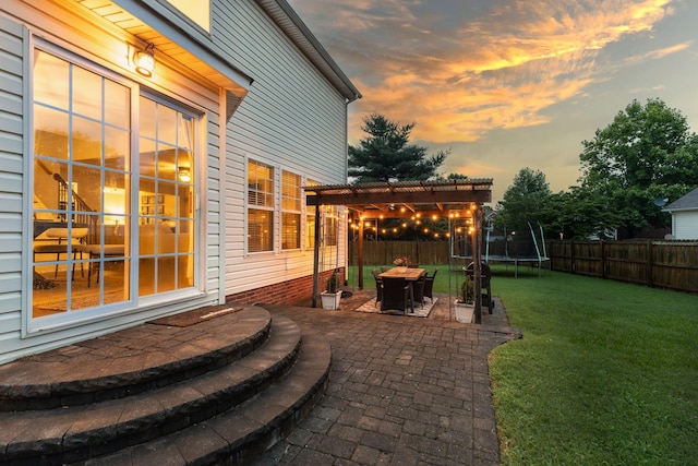 2684 Wind Dance Ct, Spring Hill, TN 37174 - patio terrace at dusk with a trampoline, a patio, a pergola, and a fenced backyard