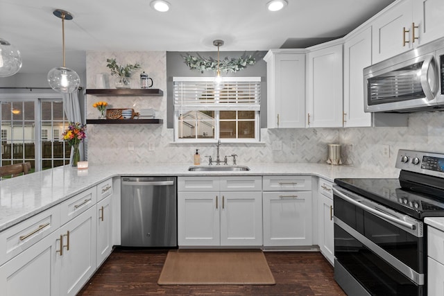 2684 Wind Dance Ct, Spring Hill, TN 37174 - kitchen with appliances with stainless steel finishes, white cabinetry, tasteful backsplash, pendant lighting, and light stone countertops