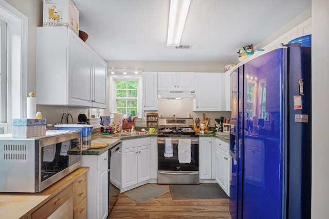 2106 Debbie Ln, La Vergne, TN 37086 - kitchen featuring stainless steel appliances, under cabinet range hood, wood finished floors, and white cabinetry