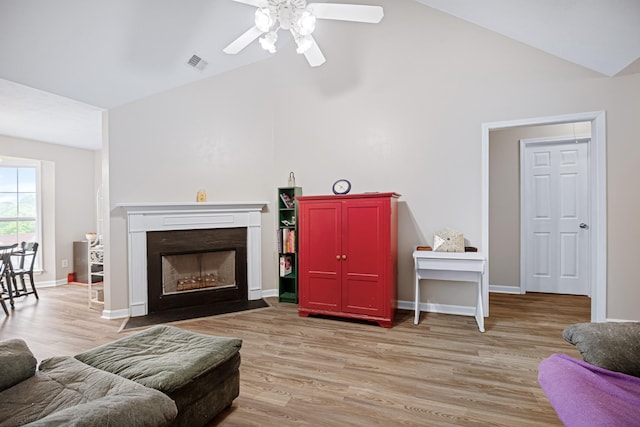2106 Debbie Ln, La Vergne, TN 37086 - living area with vaulted ceiling, a ceiling fan, light wood-style flooring, and a fireplace with flush hearth