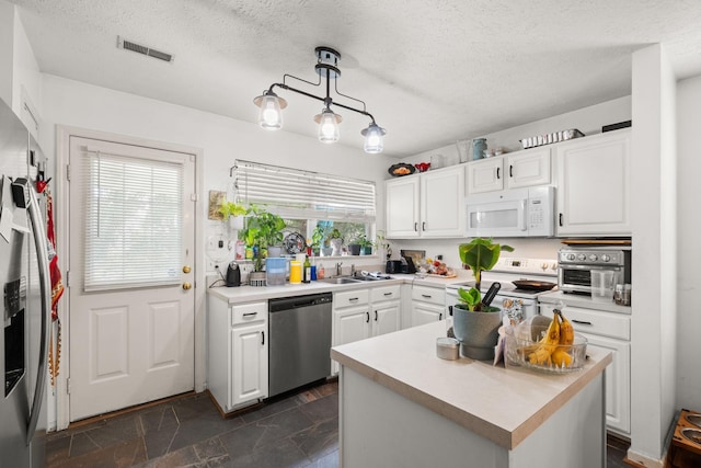 1857 Brookmeadow Ln, Hermitage, TN 37076 - kitchen featuring white appliances, white cabinetry, light countertops, a textured ceiling, and stone tile floors